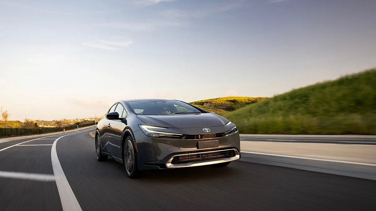 Toyota Prius Prime při jízdě při západu slunce